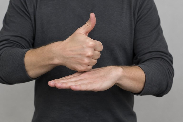 Two hands showing the vehicle classifier driving along a flat hand used as a road