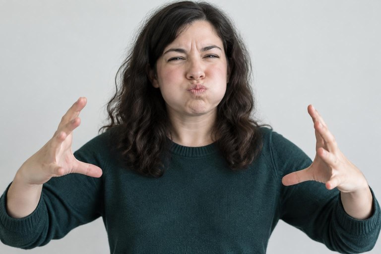 A signer with puffed cheeks pulling both hands apart to mean something huge