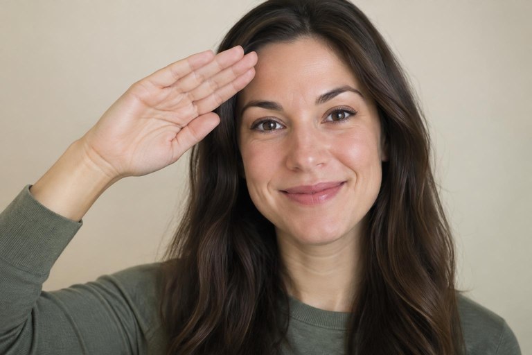 A flat hand brushing forward from the forehead in a small salute, the sign HELLO